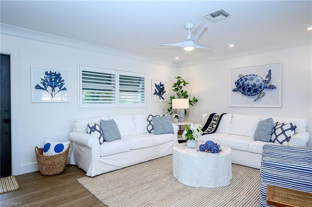 Living room with ceiling fan, hardwood / wood-style flooring, and crown molding