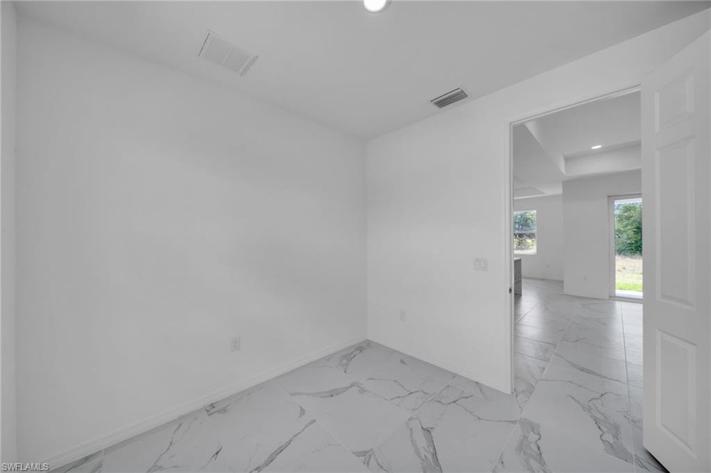 DEN White walls with marble-finish tile flooring