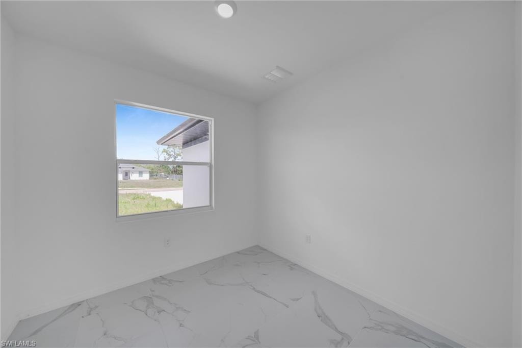 Recessed lighting, window with white frame, light-colored walls, patterned tile flooring