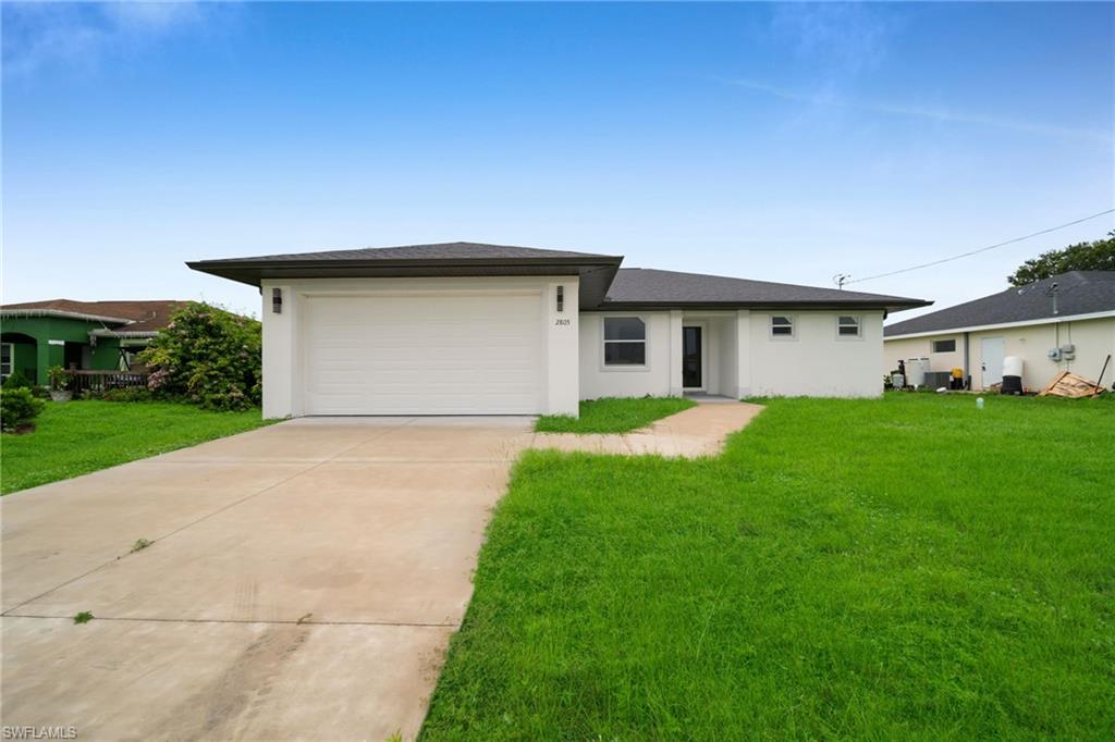 Modern ranch-style residence featuring a prominent garage, concrete driveway, and a front walkway(ENHANCED GRASS COLOR FOR VISIBILITY)