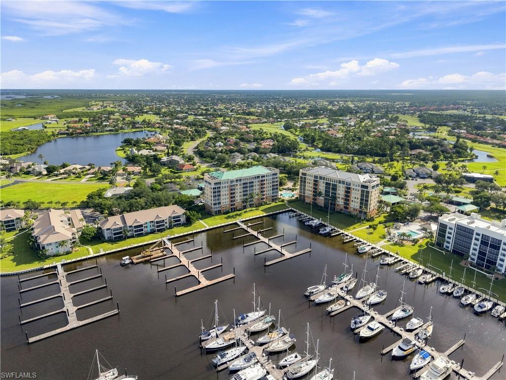 Marina with multiple boat slips, waterfront condominiums, and a surrounding landscaped community