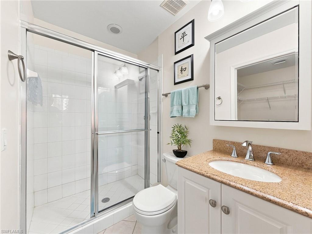 Shower enclosure with sliding glass doors, white tiled walls, and a built-in shower niche