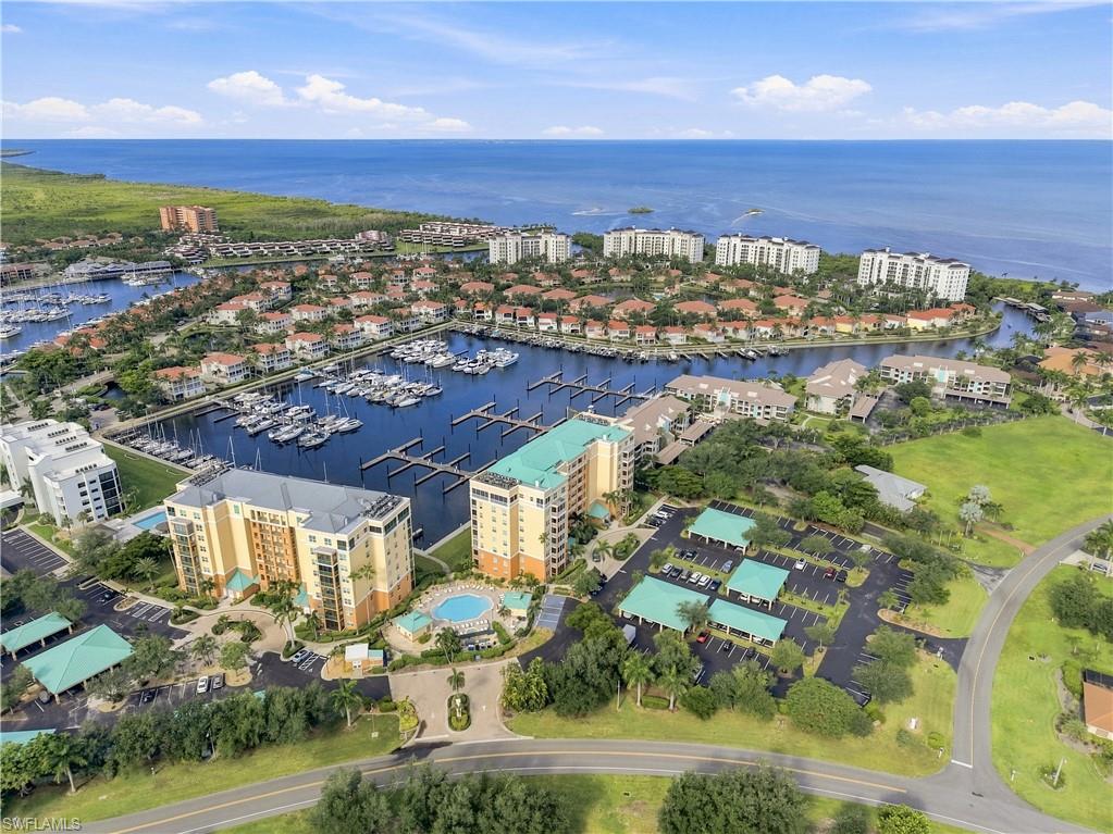 Coastal residential community with a marina, multiple multi-story buildings, covered parking, and outdoor swimming pools