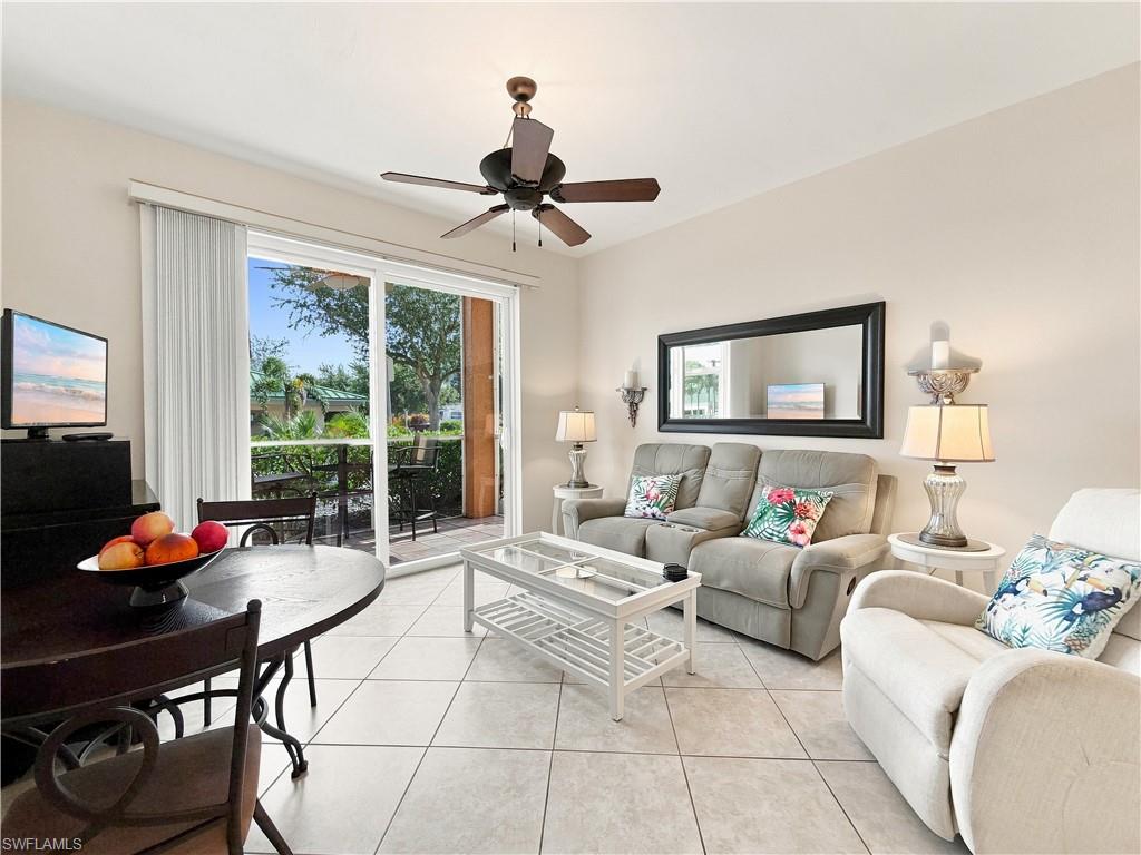 Tiled flooring throughout, ceiling fan with integrated lighting, and a sliding glass door opening to a private balcony