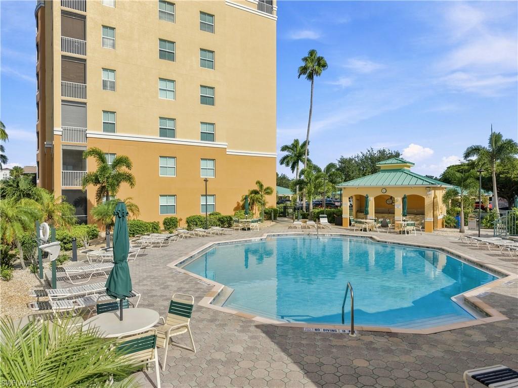 Resort-style pool area featuring a large swimming pool, surrounding paver patio, and a covered gazebo
