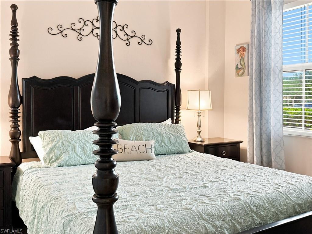Dark wood four-poster bed frame featuring a tall headboard