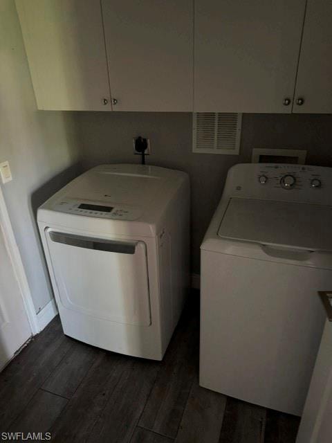 Laundry area featuring overhead cabinetry, wood-finish flooring, and light-toned walls