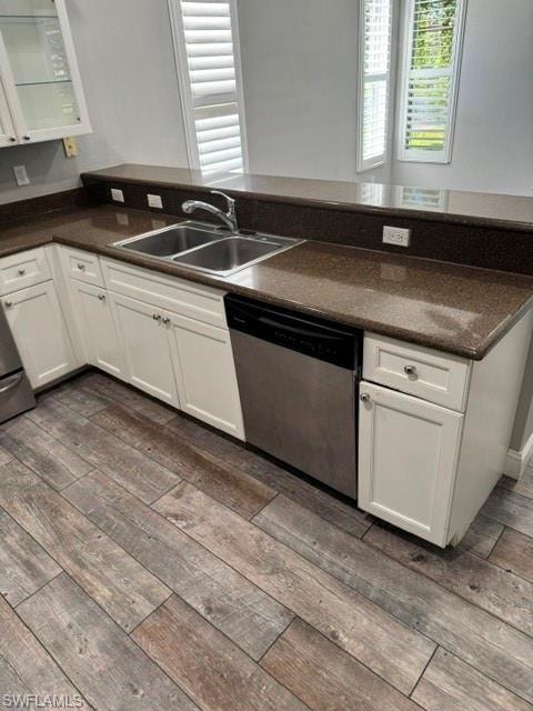 Kitchen featuring white cabinetry, dual basin stainless steel sink, stainless steel dishwasher, speckled countertops, and wood-finish flooring