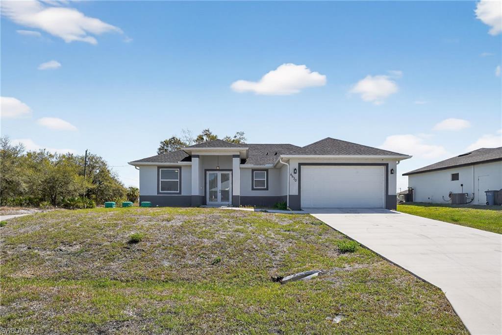 Contemporary stucco exterior with a dark shingle roof, two-car garage, and concrete driveway