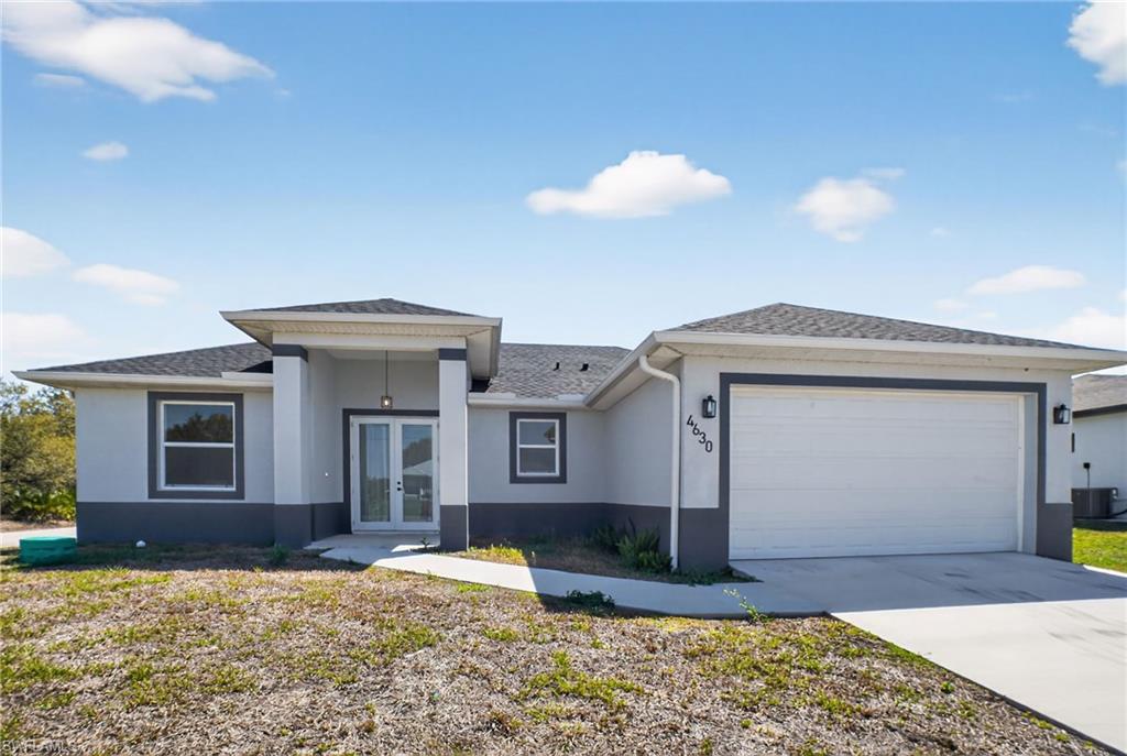 Contemporary stucco exterior with a two-tone finish, dual front entry doors, and a covered portico