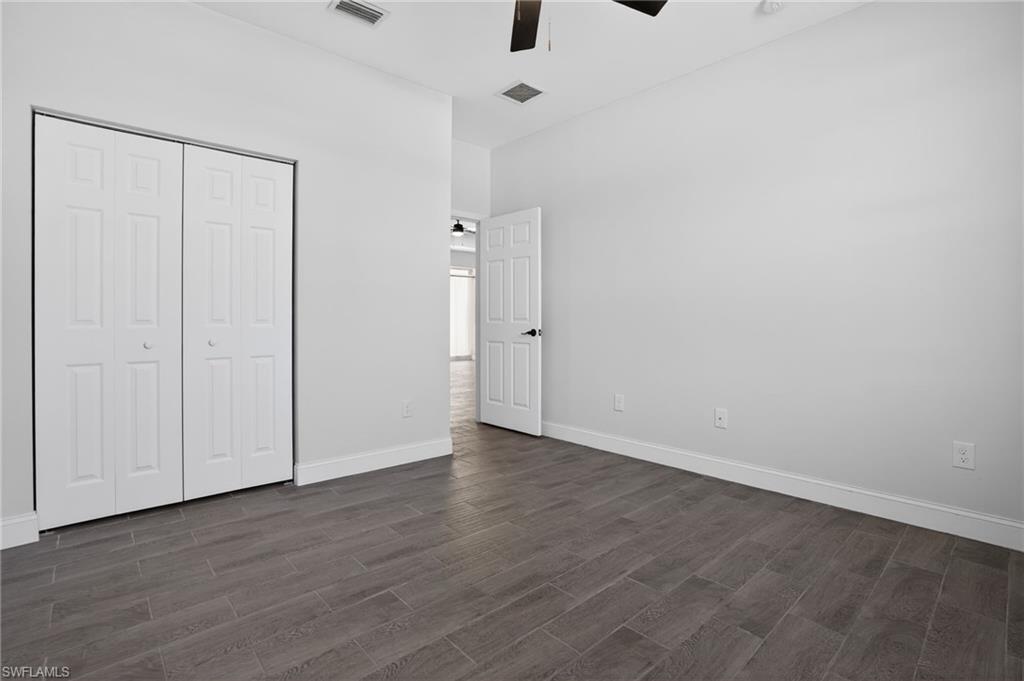 Wood-finish tile flooring throughout, white interior doors, and a ceiling fan