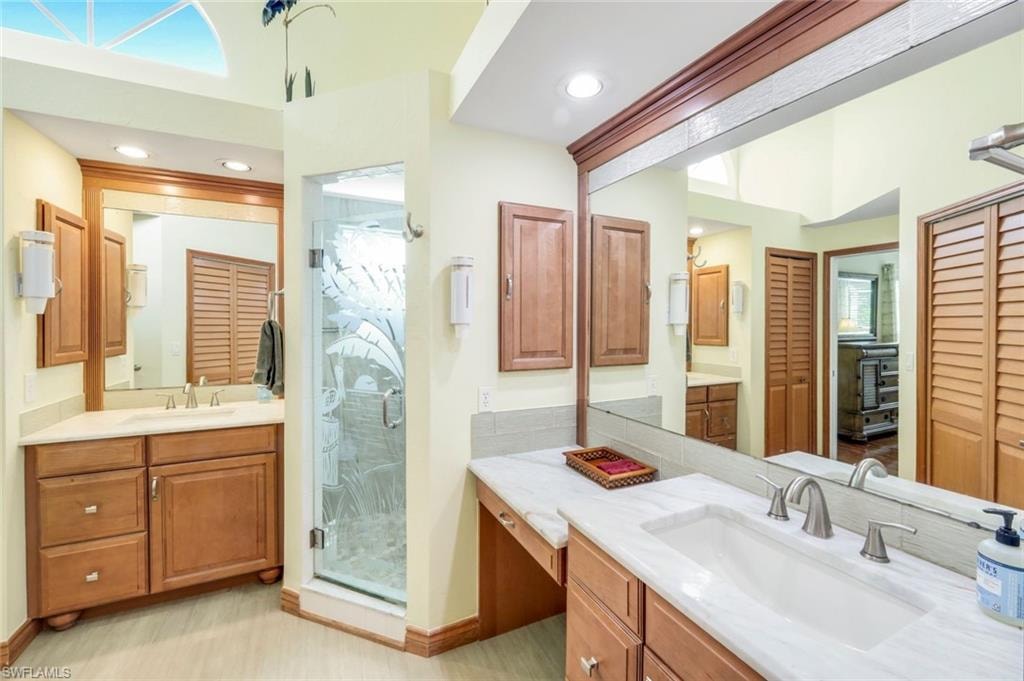 Dual vanity with undermount sinks, stone countertops, and wood cabinetry