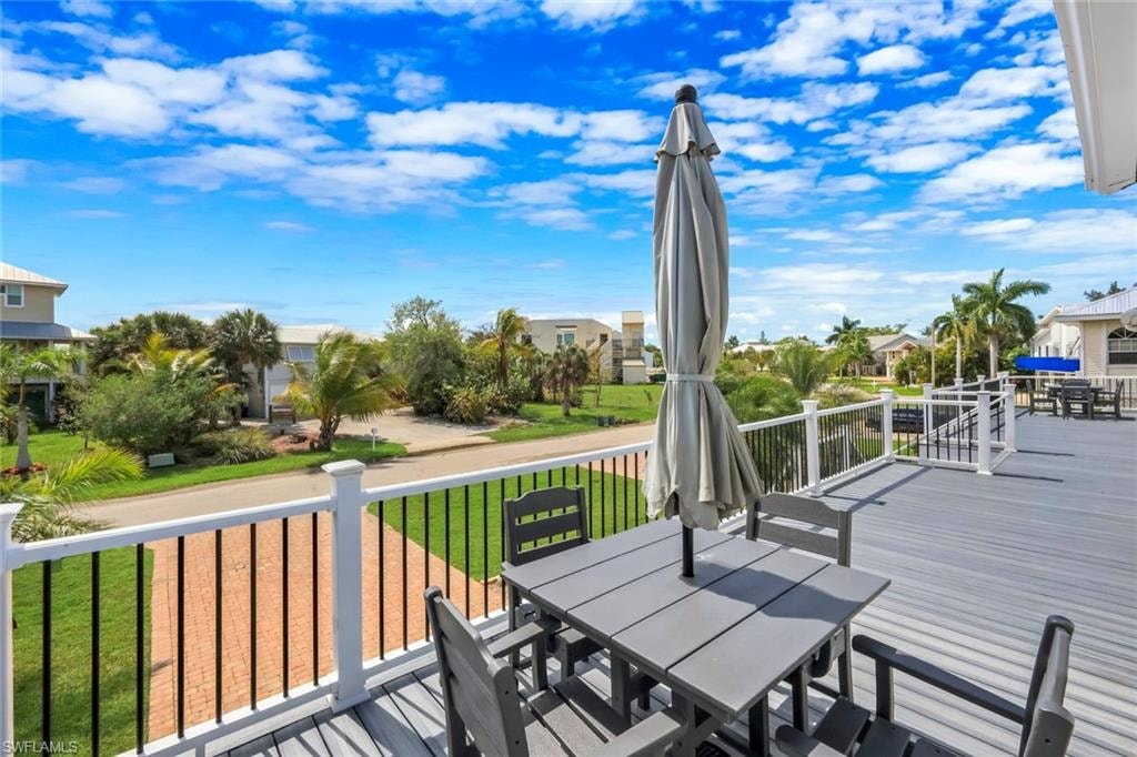 Expansive outdoor deck with composite decking and white railing, offering elevated tropical scenery