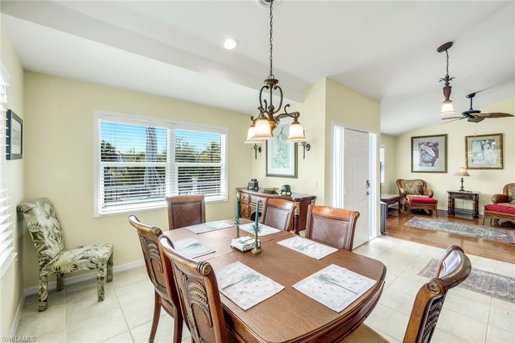 Dining area with tiled flooring, a window offering exterior views, and a multi-light chandelier