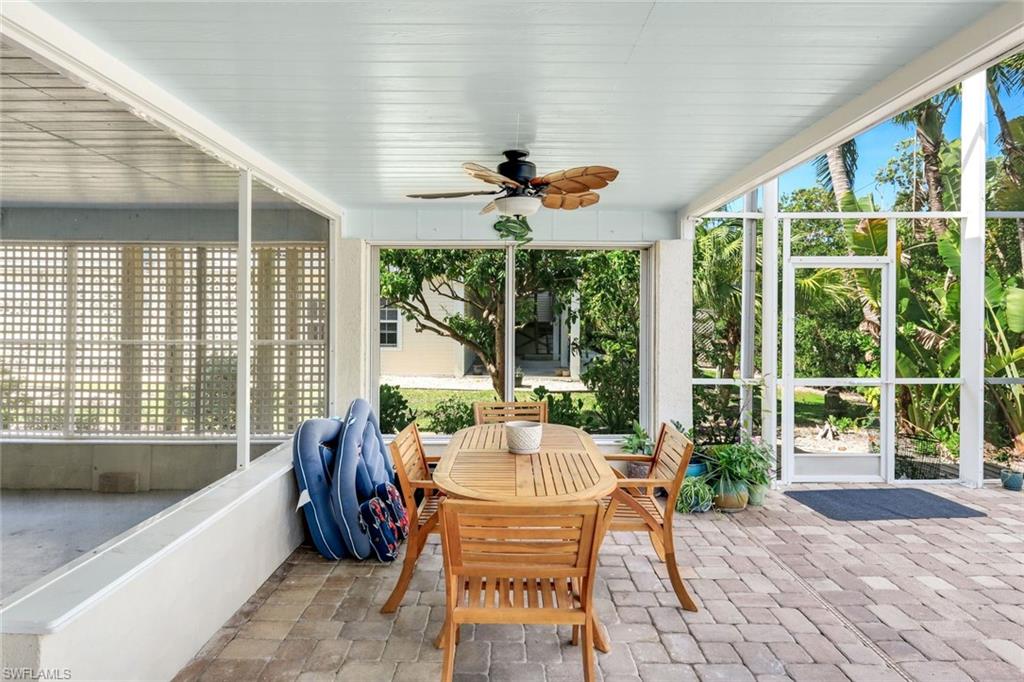 Expansive screened patio featuring paver flooring, a ceiling fan, and abundant natural light