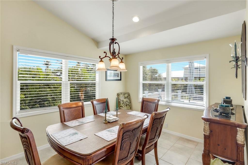 Vaulted ceiling with exposed beams, tile flooring, dual windows with blinds, and a built-in wood-finish sideboard