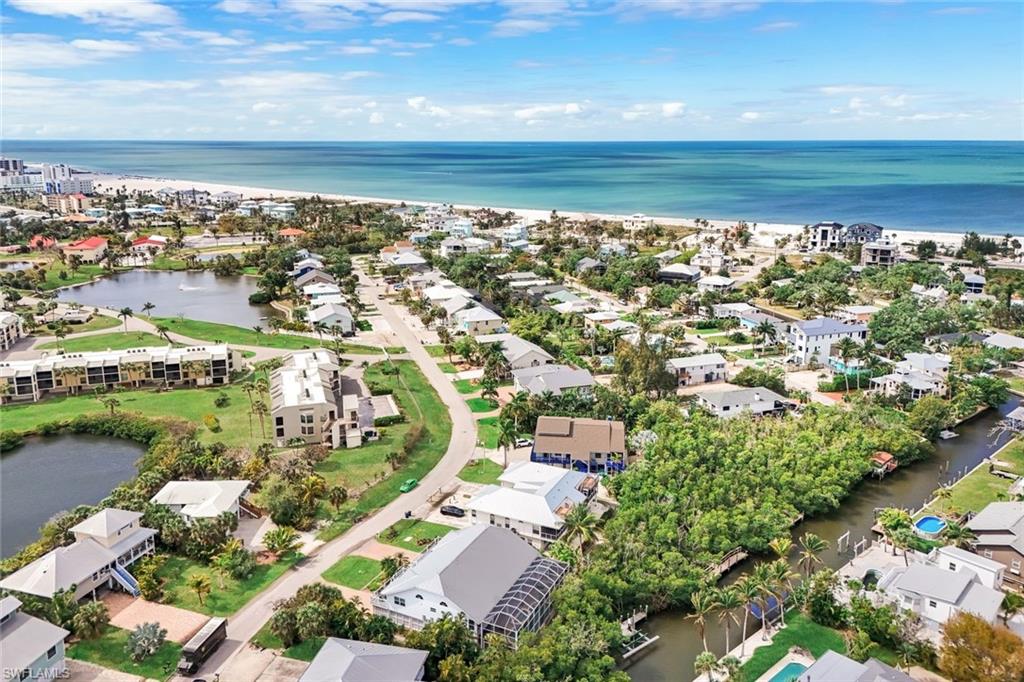 Coastal community with direct beach access, featuring canal waterways, residential properties, and natural landscaping