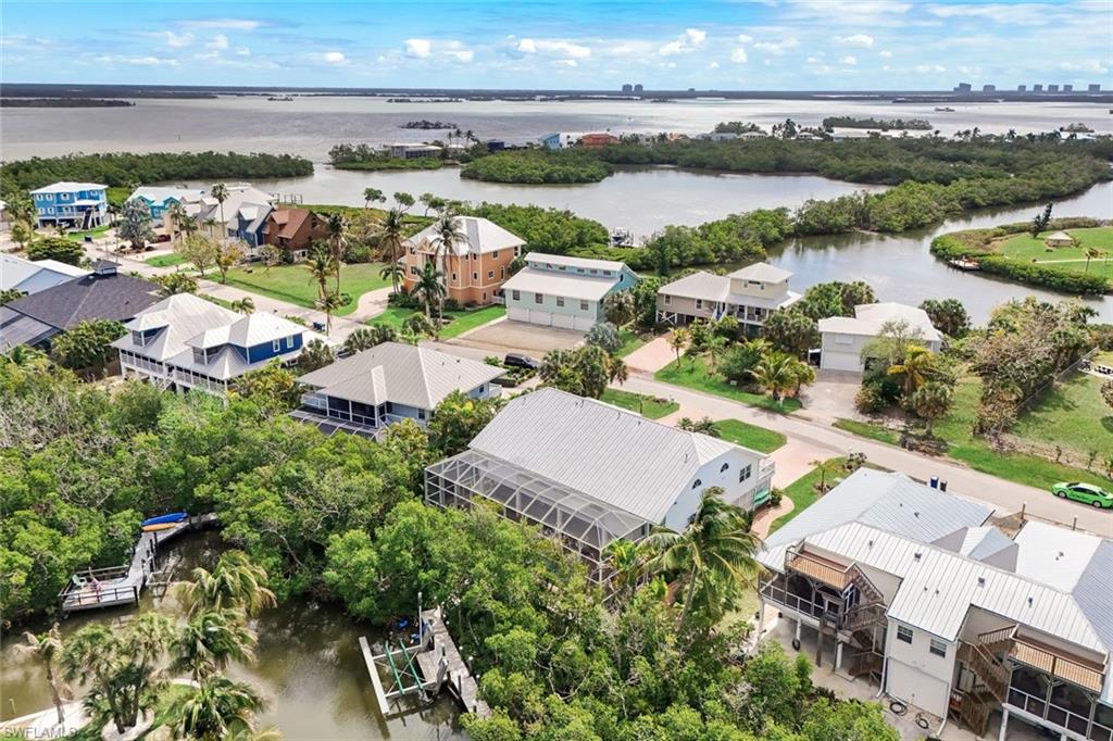 Aerial perspective showcasing multiple properties, waterway access, and lush green landscaping