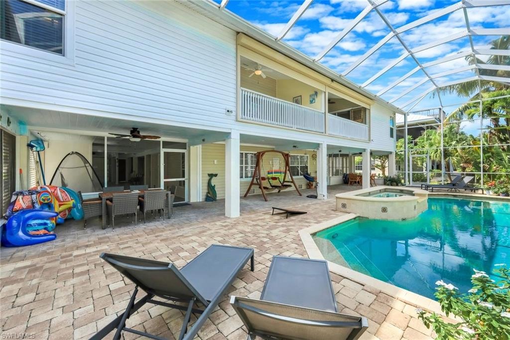 Screened outdoor living area featuring a pool, spa, and brick paver patio