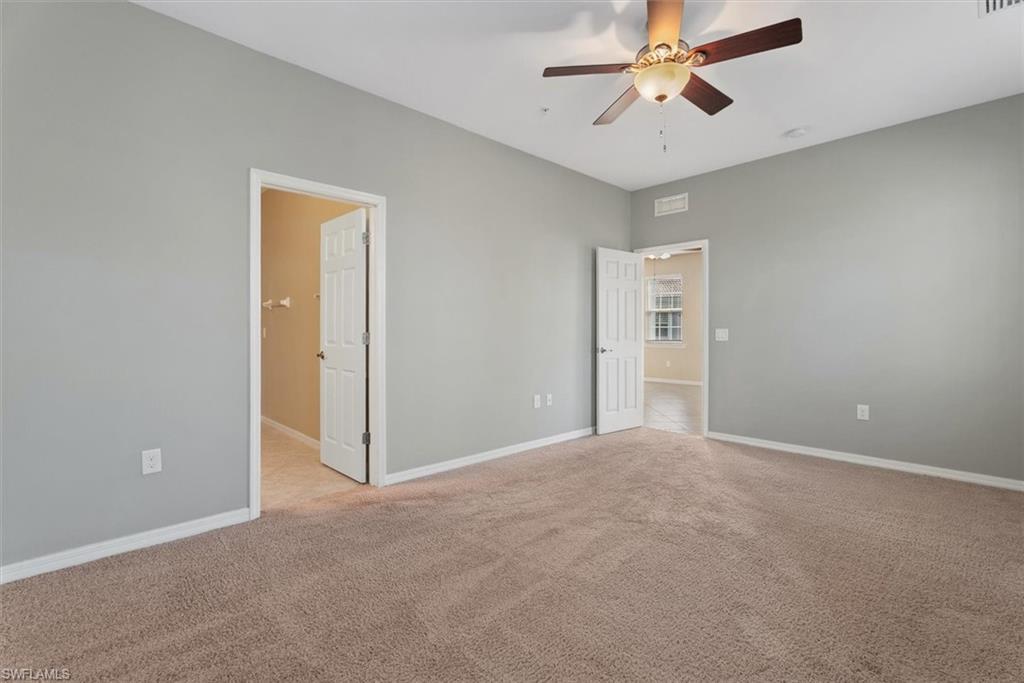 Primary bedroom Neutral gray wall paint and carpeted flooring