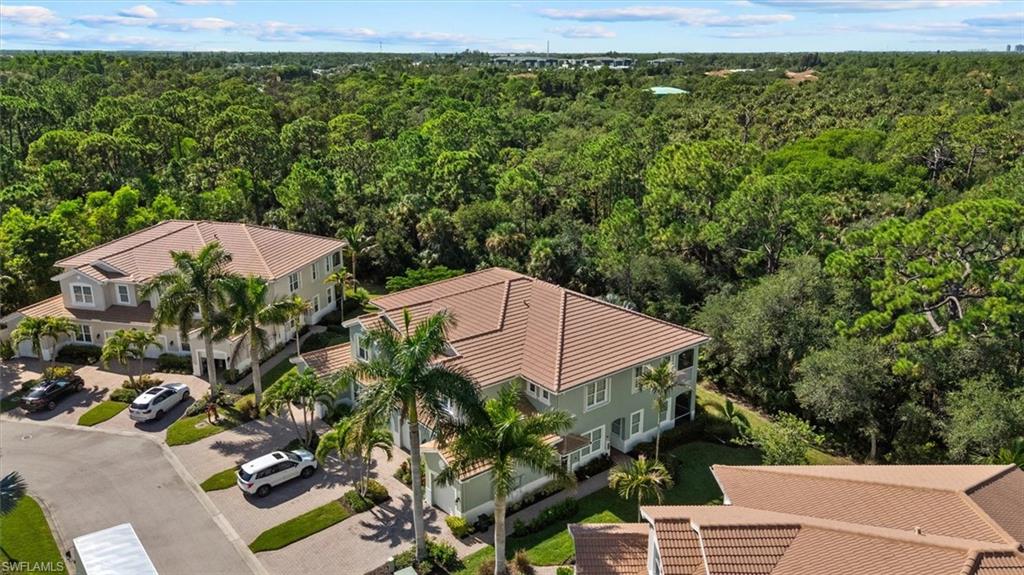 Property features a multi-story exterior with a tile roof, mature palm trees, and lush landscaping