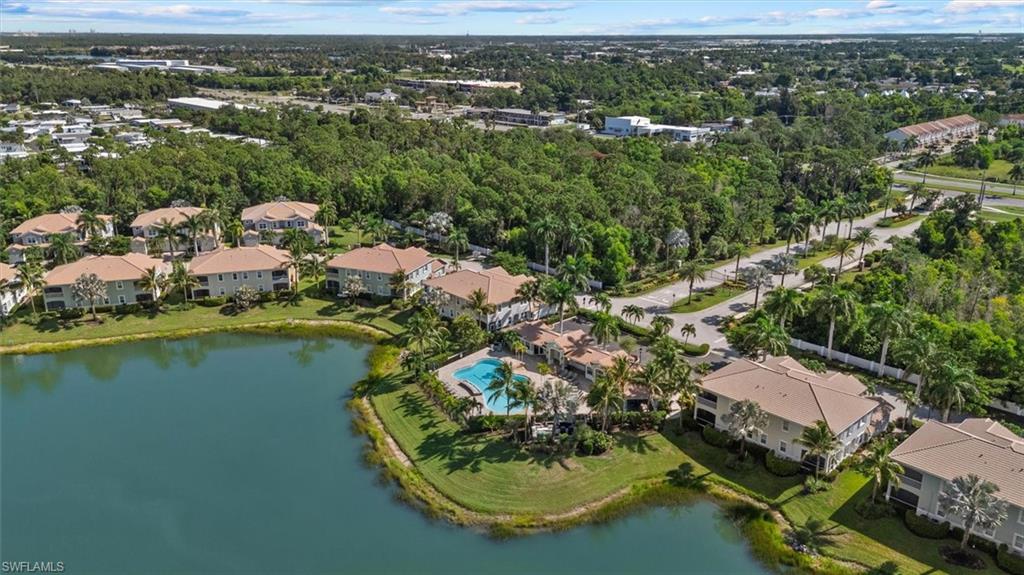 Waterfront property with multiple residential buildings, surrounded by mature trees and paved roads