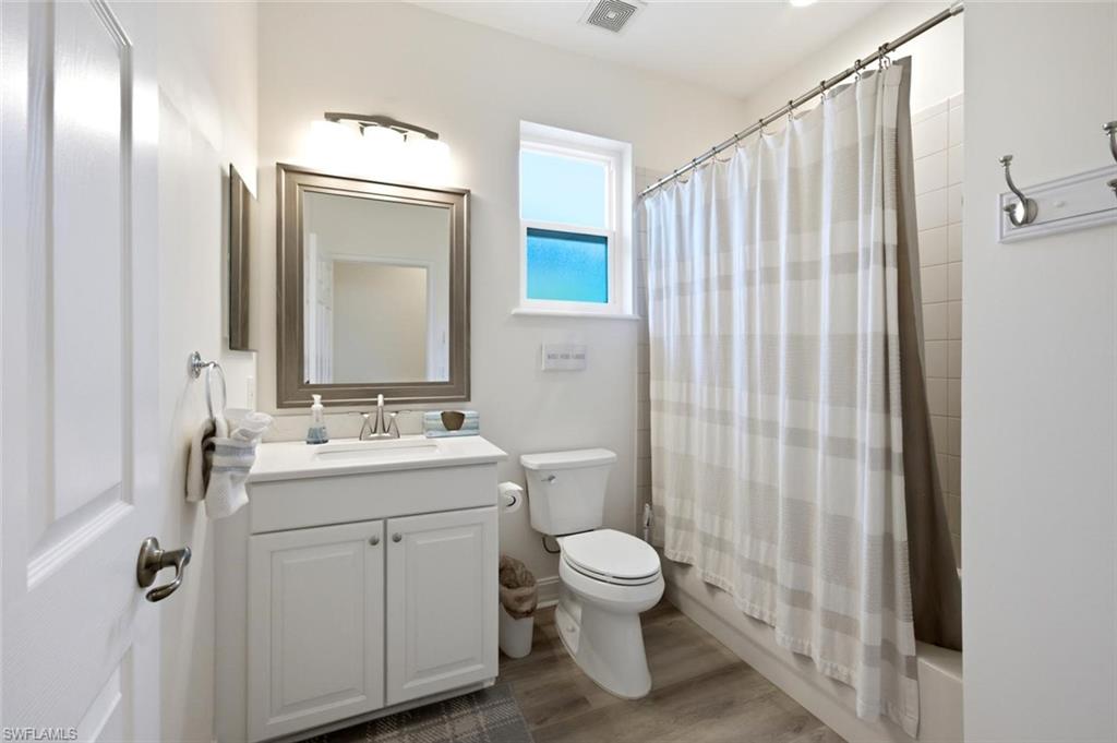 White vanity with integrated sink, framed mirror, and chrome fixtures