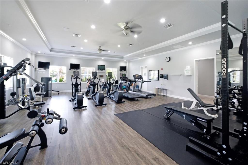 Expansive fitness center featuring wood-finish flooring, recessed lighting, and multiple windows