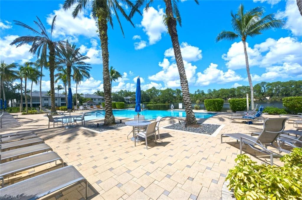 Expansive paver patio surrounding a blue-tiled swimming pool