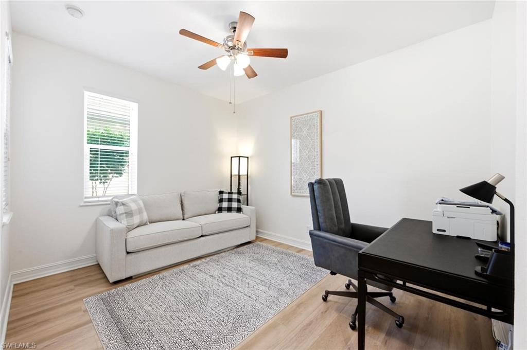 Recessed lighting, wood-finish flooring, impact window with blinds, and a ceiling fan with integrated lighting