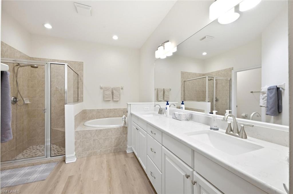 Expansive vanity with dual sinks, white cabinetry, and brushed nickel fixtures