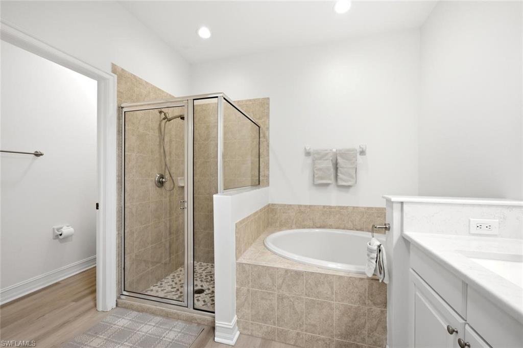 Walk-in shower with clear glass enclosure and pebble-tiled floor