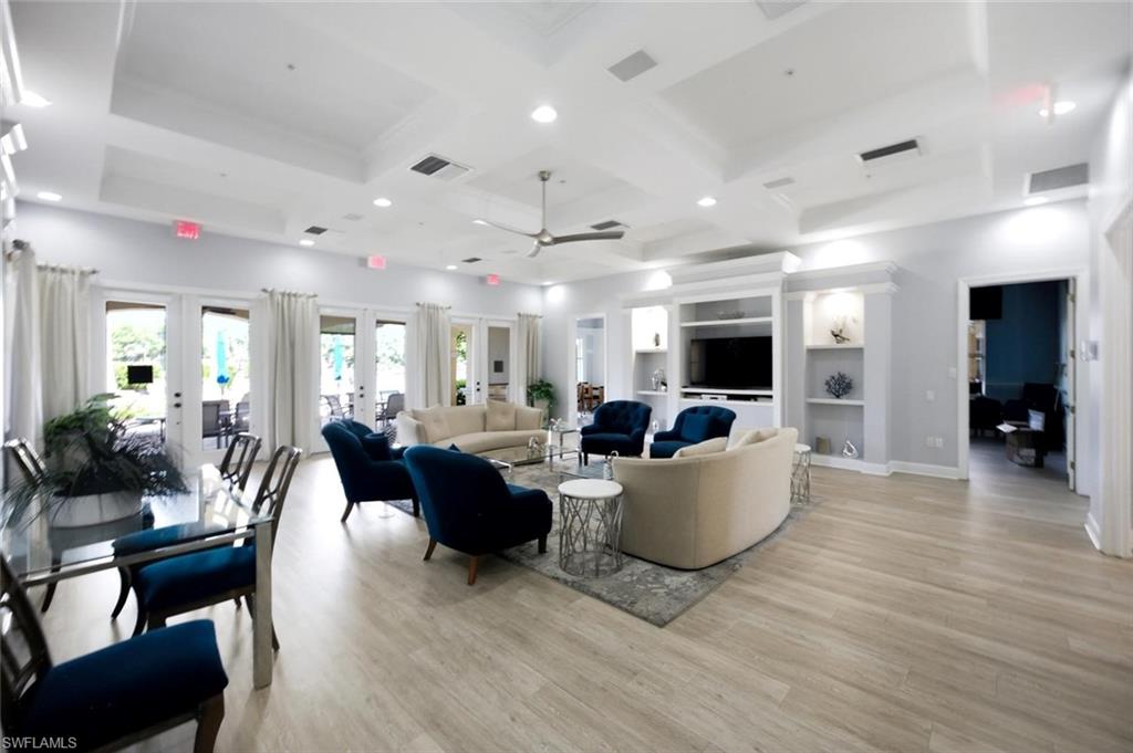 Spacious interior with high ceilings, recessed lighting, wood-finish flooring, built-in shelving, and multiple sets of French doors