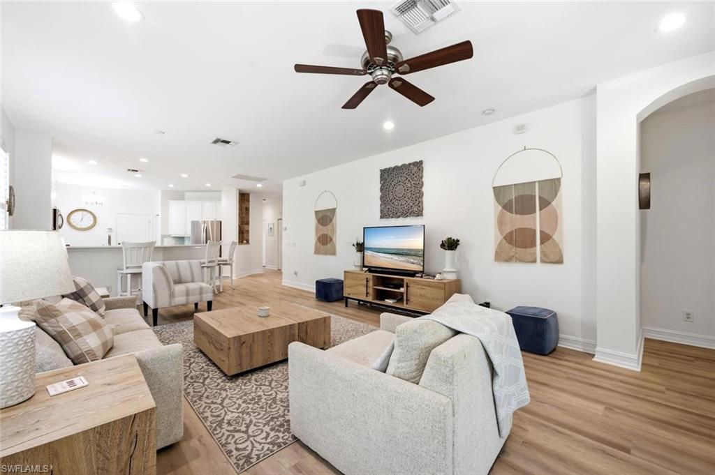 Open-concept living space with wood-finish flooring, recessed lighting, and a ceiling fan