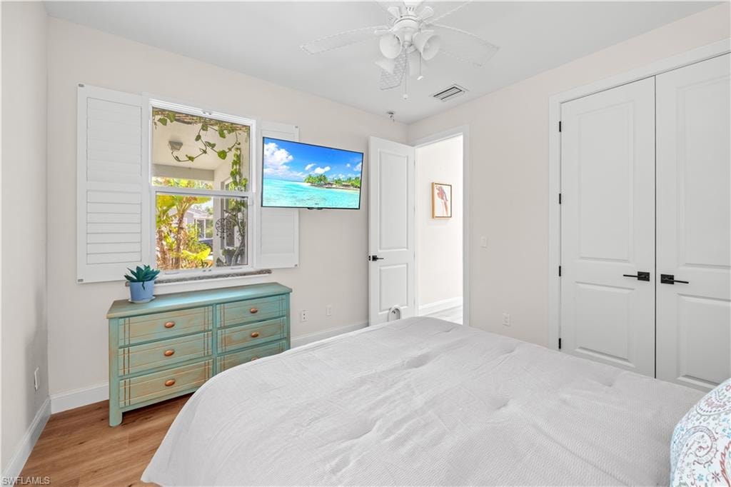 Wood-finish flooring with white walls and a white ceiling fan