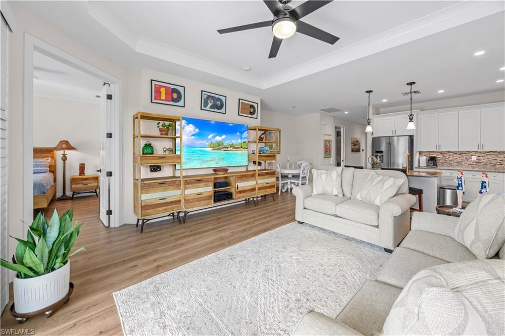 Wood-finish flooring, recessed lighting, and a ceiling fan with integrated lighting