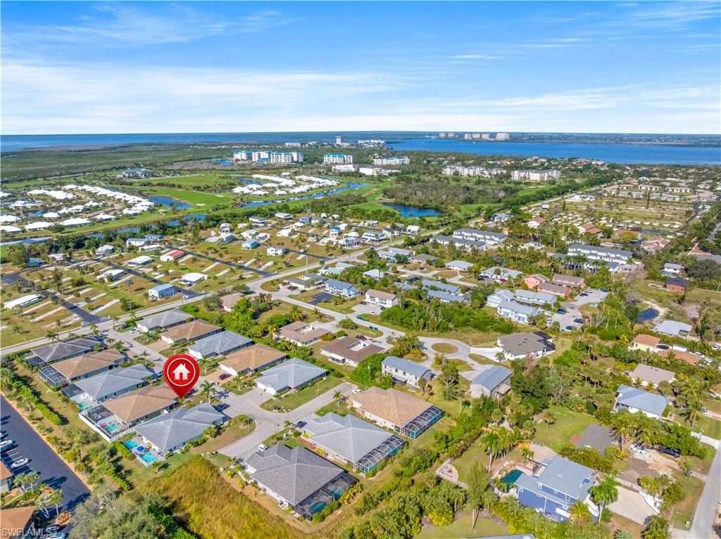 Coastal aerial perspective with expansive water backdrop, residential developments, and golf course