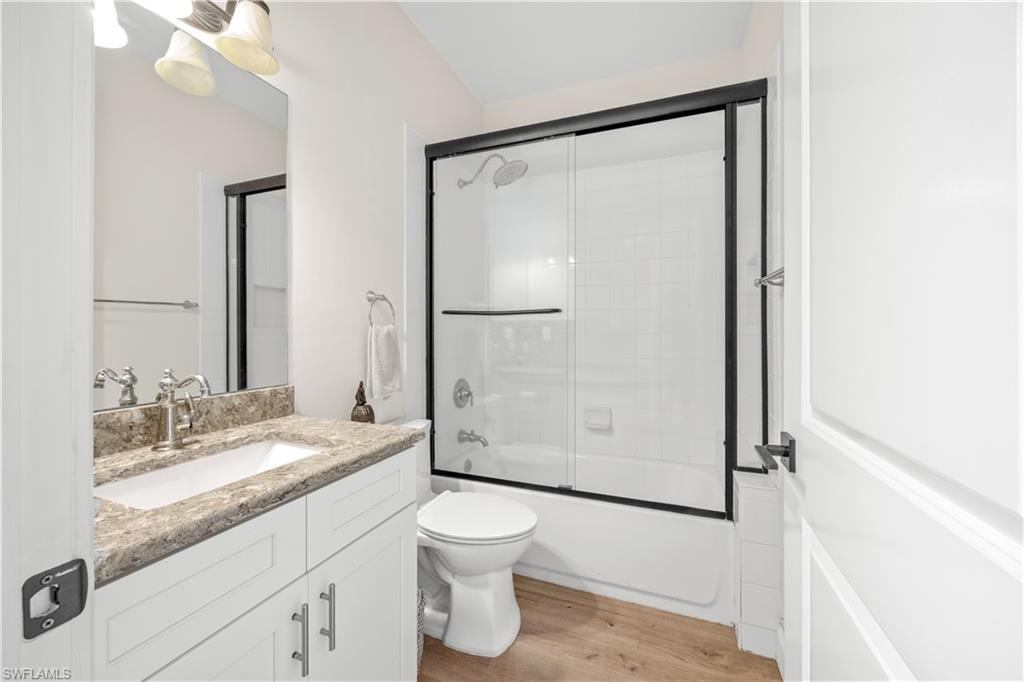 White vanity with a stone-finish countertop, under-mount sink, and chrome-finish fixtures