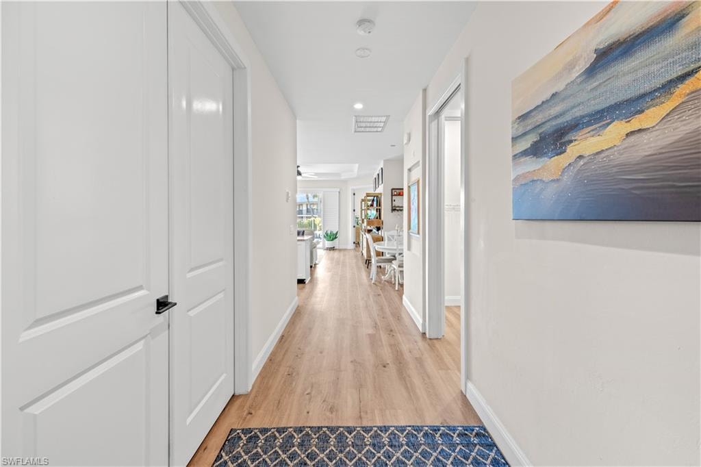 Wood-finish flooring throughout, white interior doors with black hardware, and recessed lighting