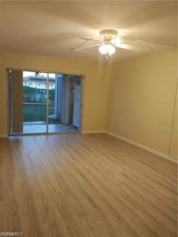 Wood-finish flooring, sliding glass doors, ceiling fan with integrated lighting, and an exterior patio with privacy screening