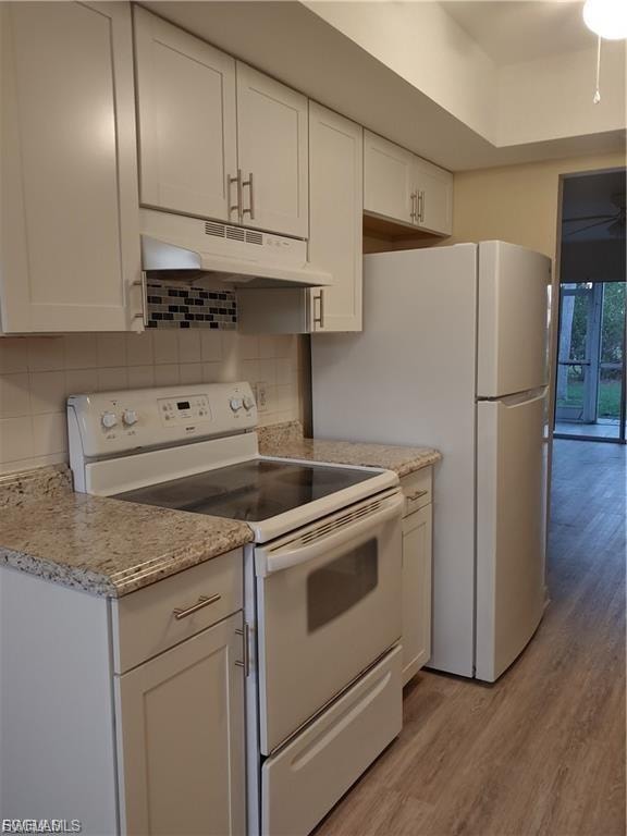 Updated kitchen featuring white cabinetry with modern hardware, granite-style countertops, stainless steel appliances including a smooth-top range and refrigerator, and a tiled backsplash accent