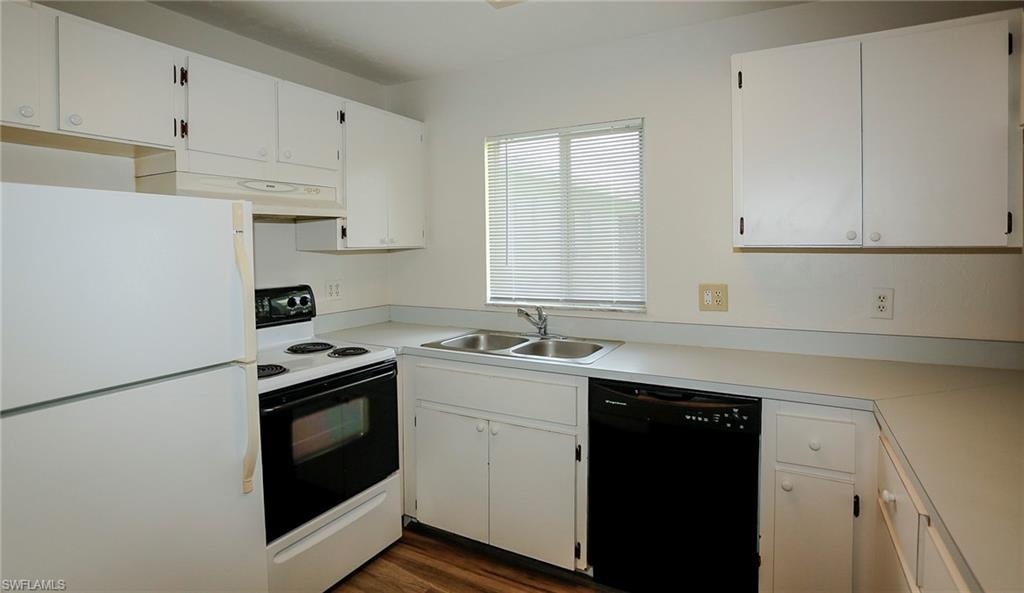 Kitchen featuring white cabinetry, white electric range, white refrigerator, black dishwasher, and a double basin stainless steel sink