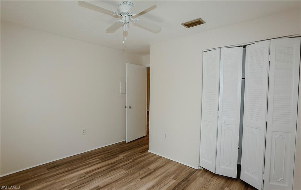 Wood-finish flooring, ceiling fan with light fixture, and bifold closet doors