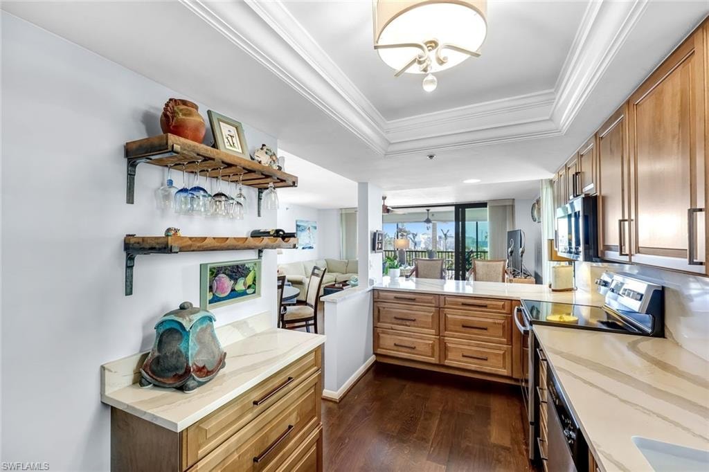 Wood-finish flooring with light wood cabinetry, stone countertops, stainless steel appliances, and a built-in wine rack