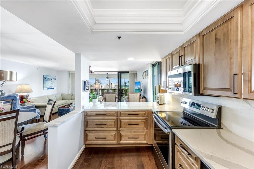 Contemporary kitchen featuring light wood-finish cabinetry, stainless steel appliances, and light-toned countertops