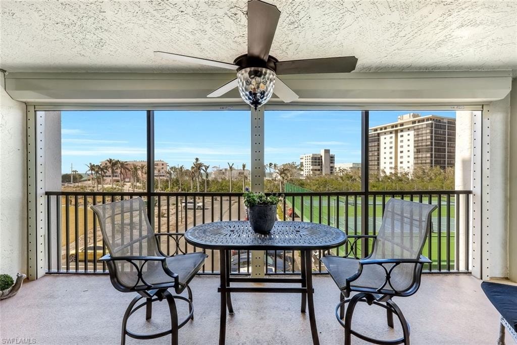 Expansive screened balcony with a ceiling fan, offering a broad scenic backdrop