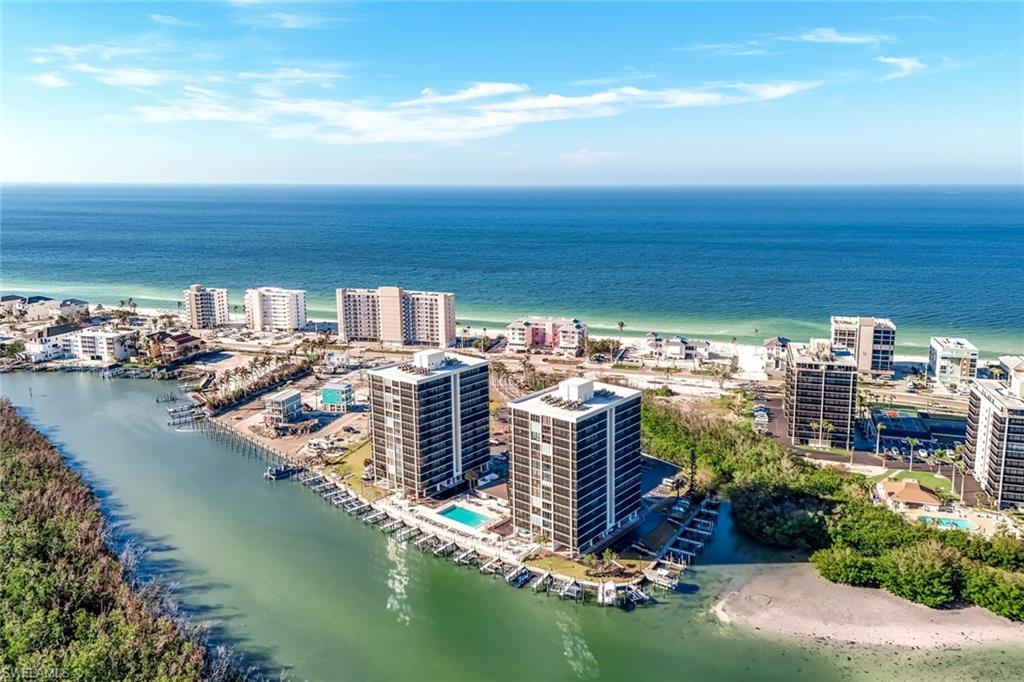 Coastal setting with direct access to a large body of water, alongside a sandy beach