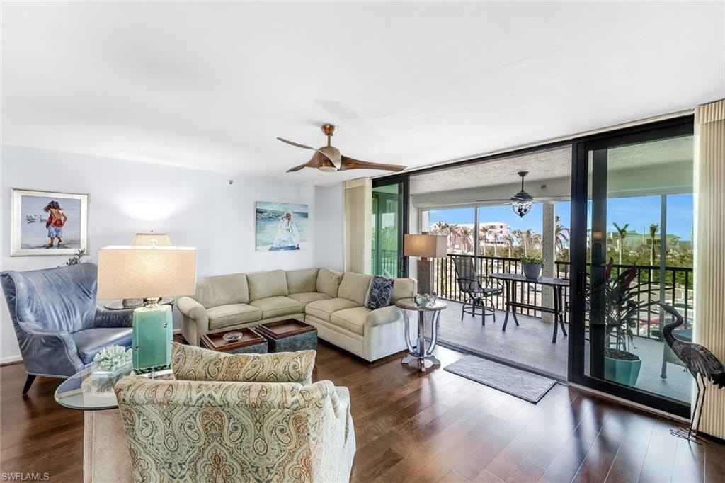 Hardwood-finish flooring, ceiling fan, and sliding glass doors opening to an outdoor balcony