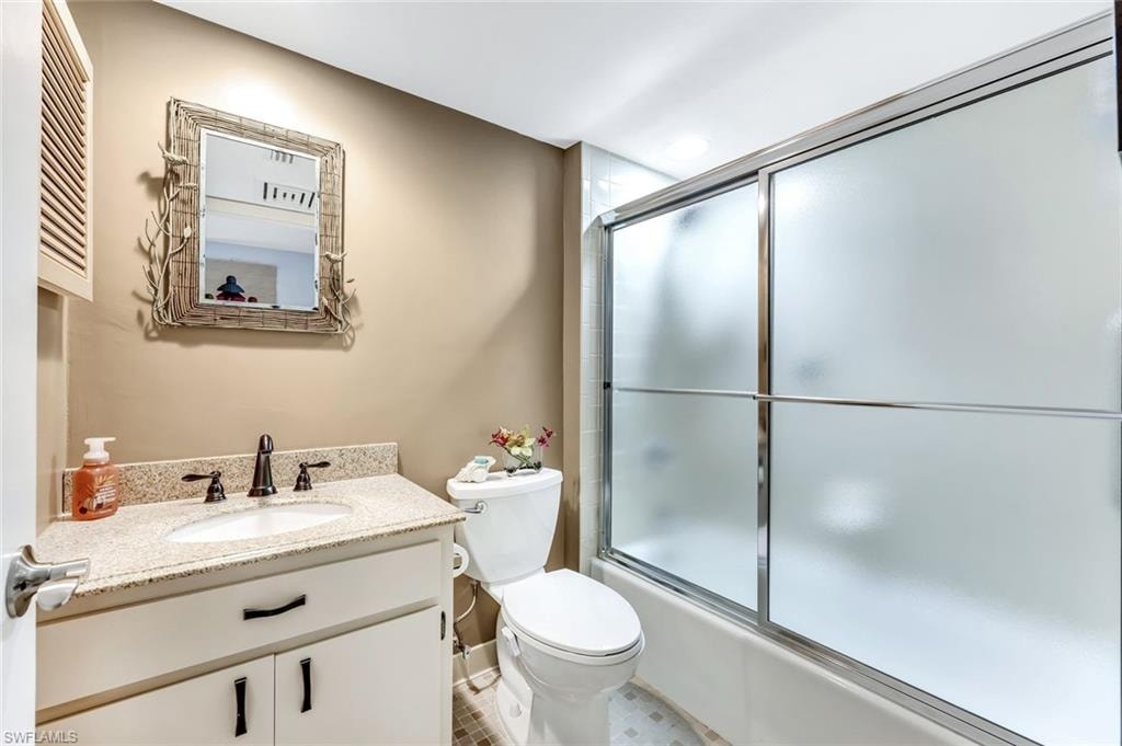 White vanity with dark hardware, granite-style countertop, and integrated sink