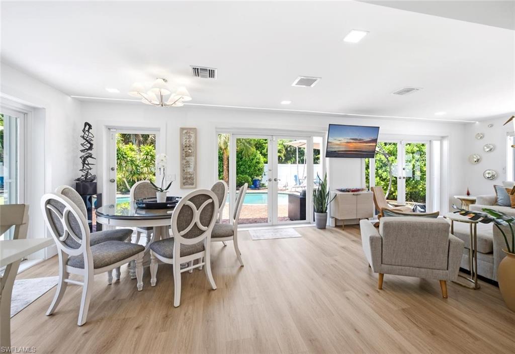 Dining area is wrapped in French doors leading out to the pool